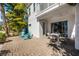 Inviting back patio with dining table, sliding glass doors, and view of tropical landscaping and blue chairs at 8012 Lost Shaker Ln, Kissimmee, FL 34747