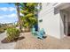 Charming patio with pavers, tropical landscaping, and cozy blue Adirondack chairs for relaxing outdoors at 8012 Lost Shaker Ln, Kissimmee, FL 34747