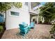 Quaint patio setting with Adirondack chairs, complemented by lush landscaping and the building's architectural details at 8012 Lost Shaker Ln, Kissimmee, FL 34747