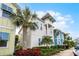 Beautiful two-story home featuring a balcony, complemented by lush landscaping and swaying palm trees at 8012 Lost Shaker Ln, Kissimmee, FL 34747