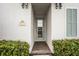 Inviting front entrance of the home with a glass door and lush green bushes either side at 8012 Lost Shaker Ln, Kissimmee, FL 34747