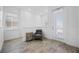 Light and airy sitting area with gray chair, wood-look tile and an exterior access door at 8012 Lost Shaker Ln, Kissimmee, FL 34747