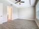 Bright bedroom with a ceiling fan, tray ceiling, and wood-look tile flooring at 806 Via Como St, Poinciana, FL 34759