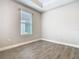 An empty bedroom with tile flooring, large window, baseboard trim, and neutral paint at 806 Via Como St, Poinciana, FL 34759