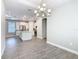 Dining room with open-concept to the kitchen features modern chandelier and wood-look tile floors at 806 Via Como St, Poinciana, FL 34759