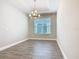 Dining room with wood-look tile floors, window, and modern chandelier at 806 Via Como St, Poinciana, FL 34759
