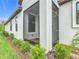 A view of the side door and a screened area surrounded by neat landscaping at 806 Via Como St, Poinciana, FL 34759