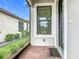 The front porch with brick flooring leads to a stylish front door and screened entrance at 806 Via Como St, Poinciana, FL 34759