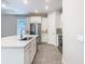 Bright kitchen featuring white cabinets, stainless steel appliances, quartz countertops, and a stylish backsplash at 806 Via Como St, Poinciana, FL 34759