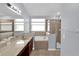 Well-lit bathroom featuring dual sinks, a soaking tub, and a separate glass-enclosed shower at 923 Tramells Trl, Kissimmee, FL 34744