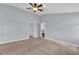 Spacious bedroom with a ceiling fan, neutral carpet, and an adjoining walk-in closet and bathroom at 923 Tramells Trl, Kissimmee, FL 34744