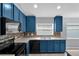Well-lit kitchen with stylish blue cabinets and stainless steel appliances at 923 Tramells Trl, Kissimmee, FL 34744