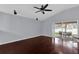 Spacious living room with hardwood floors, ceiling fan, and sliding glass door at 923 Tramells Trl, Kissimmee, FL 34744