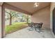 Covered patio featuring metal table and chairs with a view of a grassy backyard at 923 Tramells Trl, Kissimmee, FL 34744