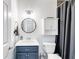Bathroom features a stylish vanity with a blue base and round mirror, complemented by a shower at 9559 Dubois Blvd, Orlando, FL 32825