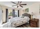 Bright bedroom with a ceiling fan, gray curtains, and sliding door access to the outdoor patio at 9559 Dubois Blvd, Orlando, FL 32825