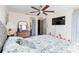 Spacious bedroom with ceiling fan, TV, and a dresser with a mirror near the closet at 9559 Dubois Blvd, Orlando, FL 32825