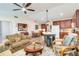 Open-concept living space featuring wood floors, a kitchen island, and comfortable seating at 9559 Dubois Blvd, Orlando, FL 32825