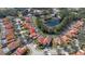 An aerial view featuring terracotta homes surrounding a glistening pond and lush landscaping at 113 Tiger Lily Ct, Davenport, FL 33837