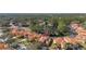 Aerial view of a neighborhood featuring homes with red-tiled roofs, screened in pools, and lush, green landscaping at 113 Tiger Lily Ct, Davenport, FL 33837
