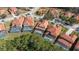Aerial view of a home with a screened-in pool, surrounded by manicured lawns, and nearby lush trees at 113 Tiger Lily Ct, Davenport, FL 33837