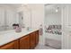 Bathroom with a vanity and mirror, leading to a bright bedroom at 113 Tiger Lily Ct, Davenport, FL 33837