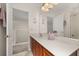 Bathroom with a sink, spacious countertop, cabinets, shower, and a view of the hallway at 113 Tiger Lily Ct, Davenport, FL 33837
