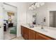 Bright bathroom featuring double sinks, modern fixtures, and a view into the adjacent bedroom at 113 Tiger Lily Ct, Davenport, FL 33837