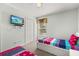 A bright bedroom with two beds featuring colorful bedding, a ceiling fan, and ample natural light at 113 Tiger Lily Ct, Davenport, FL 33837