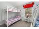 bedroom with bunkbeds and a window with a red shade in a Gathering home at 113 Tiger Lily Ct, Davenport, FL 33837