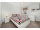 Cozy bedroom with a colorful geometric-patterned bedspread, nightstands, and a dresser against the white wall at 113 Tiger Lily Ct, Davenport, FL 33837