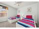 This bedroom features two beds with vibrant, patterned bedding and framed art on the walls at 113 Tiger Lily Ct, Davenport, FL 33837