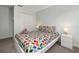 Bedroom with a bright chevron patterned bedcover and white nightstands with lamps at 113 Tiger Lily Ct, Davenport, FL 33837