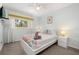 Bright bedroom with large window, ceiling fan and a bed with colorful patterned comforter at 113 Tiger Lily Ct, Davenport, FL 33837