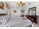 This bedroom includes a ceiling fan, TV and a dark wood dresser with mirror at 113 Tiger Lily Ct, Davenport, FL 33837