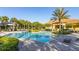 The Watersong community pool features lounge chairs, lush palm trees, and manicured landscaping at 113 Tiger Lily Ct, Davenport, FL 33837