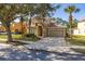 Charming two-story home with tile roof, arched entry, and well-manicured landscaping at 113 Tiger Lily Ct, Davenport, FL 33837