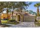 Charming two-story home with tile roof, arched entry, and well-manicured landscaping at 113 Tiger Lily Ct, Davenport, FL 33837