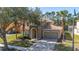 Charming two-story home with tile roof, arched entry, and well-manicured landscaping at 113 Tiger Lily Ct, Davenport, FL 33837