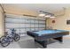 Garage area with a billiards table, bikes, and overhead lighting at 113 Tiger Lily Ct, Davenport, FL 33837