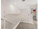 Upstairs hallway with carpet flooring, white banister, and view of the entryway at 113 Tiger Lily Ct, Davenport, FL 33837