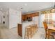 Open kitchen with breakfast bar, wooden cabinets, and a dining area nearby at 113 Tiger Lily Ct, Davenport, FL 33837