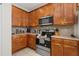 Updated kitchen showcasing stainless steel appliances and attractive wood cabinetry at 113 Tiger Lily Ct, Davenport, FL 33837