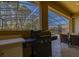 Built-in outdoor kitchen with BBQ grill features a view of the enclosed pool at 113 Tiger Lily Ct, Davenport, FL 33837