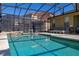 The sparkling screened-in pool provides a refreshing escape with views of the neighboring homes at 113 Tiger Lily Ct, Davenport, FL 33837