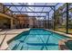 The sparkling screened-in pool provides a refreshing escape with views of the neighboring homes at 113 Tiger Lily Ct, Davenport, FL 33837