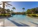 Beautiful community pool surrounded by palm trees and manicured landscaping at 113 Tiger Lily Ct, Davenport, FL 33837