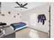 bedroom with a large window, ceiling fan, bed and superhero themed wall decor at 1185 Catskill Dr, Haines City, FL 33844