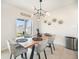 Bright dining room features a modern chandelier, wood table, and sliding door to the backyard at 1185 Catskill Dr, Haines City, FL 33844