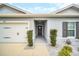 Inviting front entrance with decorative door wreath, clean landscaping, and attached garage at 1185 Catskill Dr, Haines City, FL 33844